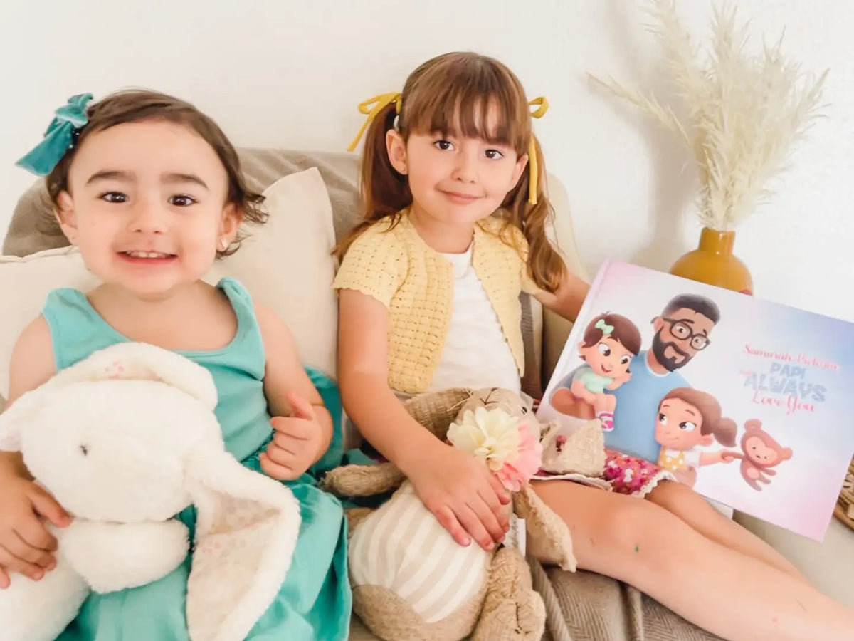Deux petites filles avec le meilleur cadeau pour Papa : un livre personnalisé où ils sont les vedettes des histoires.