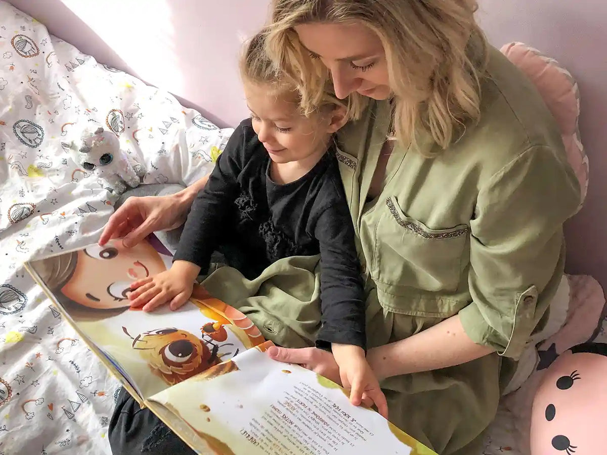 Une maman et sa fille lisent un livre d'anniversaire personnalisé.