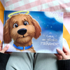 Personne tenant un livre mémoire personnalisé pour chien intitulé « Coco, une étoile au firmament ».