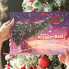 Livre personnalisé “Notre Premier Noël 2025” avec Lucas et Papou, tenu devant un sapin de Noël décoré.